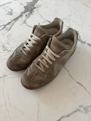 Maison margiella  - Snygga beige kicks. I bra skick och riktigt stilrena och skön färg nu till sommaren. Storlek 41 passar 42. Lagade precis under sulan på hälarna så därför det ser annorlunda ut.