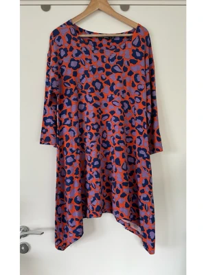 Lila-orange leopardklänning - Gudrun Sjödén- storlek M - Härlig klänning från Gudrun Sjödén i storlek M med trekvartsärm och en båthalsringning. Klänningen har ett lekfullt leopardmönster i lila och mörkblått mot en orange botten. Nederkanten är asymmetrisk vilket ger ett unikt fall. 94% lyocell, så bra naturmaterial som andas, perfekt inför vår och sommar. Nypris 1295:-. Mycket gott skick, som ny!