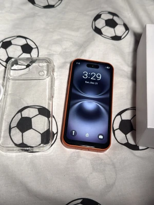 Blå,orange och vitt iPhone med trippelkamera - Snygg orange mini iPhone med stilren design och trippelkamera på baksidan. Telefonen har en platt skärm med tunna kanter och levereras med ett genomskinligt skal. Perfekt för dig som vill sticka ut med en färgglad mobil från Apple. Allt på bilderna ingår 