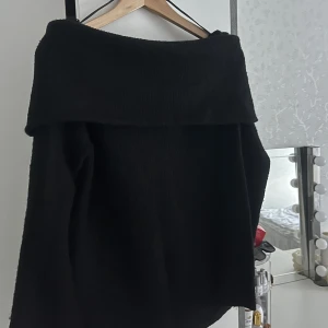 Svart off-shoulder tröja (Stickad) - Jag säljer denna jättemysiga och underbara off-shoulder tröjan från H&M i storlek XS. Den är mysig och sticks inte vilket andra stickade tröjor gör. Den går att styla till allt. Endast använd 2-3 gånger!