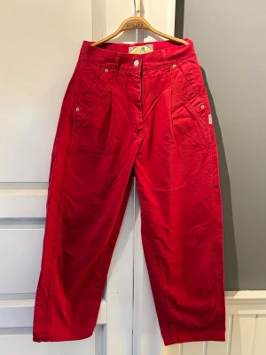 Vintage röda byxor - Vintage röda byxor med hög midja och veck framtill. Rak/avslappnad passform med fin struktur 