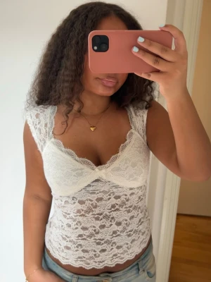 Vit v-ringad spetstop - Säljer denna superfina spetstoppen som är lite genomskinlig på magen och har spetsdetaljer vid v-ringningen🤍