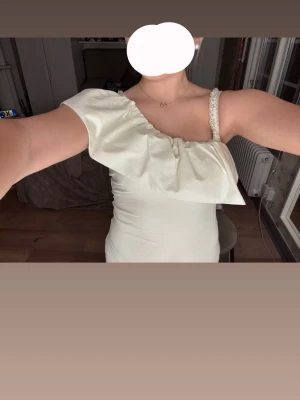 Vit oneshoulder topp med volang🙌🏼😍 - Snygg vit topp med oneshoulder-design och bred volang över bröstet. Toppen passar alla outfits! Storlek xs och använd bara ett fåtal gånger🥰
