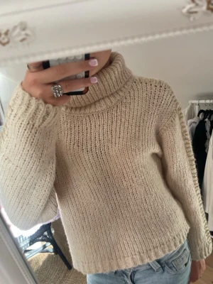 Jättefin beige stickad tröja - Jättefin beige stickad turtleneck tröja med guldiga detaljer. Tryck gärna på köp nu! 💛