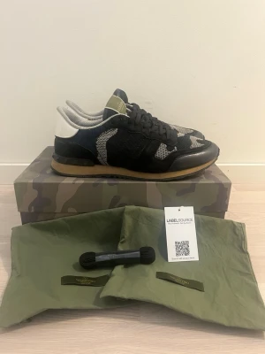 Svarta sneakers med mesh och mocka - Snygga svarta sneakers med detaljer i grå mesh och svart mocka. Skon har svarta skosnören, beige sula och sportig design. Perfekt för dig som gillar streetstyle och bekväma skor med cool look.