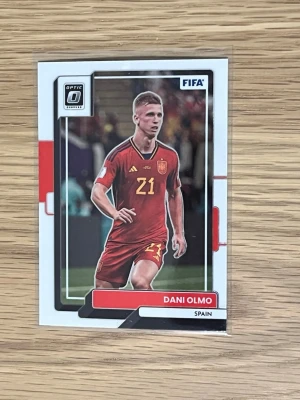FIFA fotbollssamlarbild Dani Olmo - Samlarbild från Panini Donruss Soccer Optic 2022-23 med Dani Olmo i Spaniens landslagströja. Kortet har färger i rött, vitt och svart och visar spelaren i matchställ med nummer 21. Perfekt för dig som gillar fotboll och samlarkort.