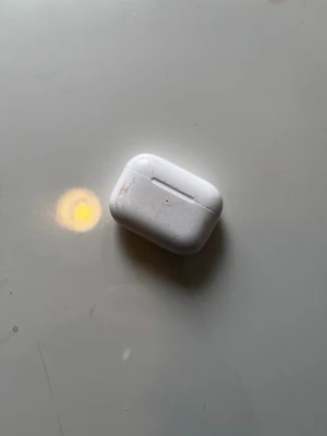 Apple AirPods Pro med laddningsetui - Säljer ett par Apple AirPods Pro med vitt laddningsetui. Hörlurarna är trådlösa och har en kompakt, rundad form. De är tillverkade i plast och har silikonproppar för bättre passform och ljudisolering. Perfekt för musik, poddar och samtal.
