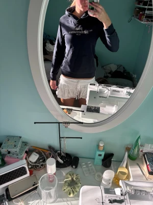 Mörkblå Peak Performance hoodie - Säljer en mörkblå hoodie från Peak Performance med vit logotyp på bröstet. Hoodien har en klassisk huva och en stor magficka framtill. Perfekt för dig som gillar sportig och avslappnad stil. Materialet är mjukt och bekvämt.