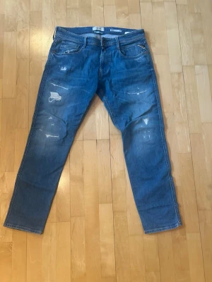 Replay anbass jeans  - Säljer ett par blå jeans replay ambass jeans med slitningar. Storlek 32 i midjan och 30 på längden. 