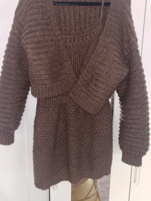 Brun stickad omlottopp från SHEIN - Säljer en brun stickad omlottopp från SHEIN med djup v-ringning och långa ärmar. Tröjan har en ribbad struktur och breda muddar vid ärmslut och nederkant. Perfekt för lager på lager och riktigt mysig till hösten.
