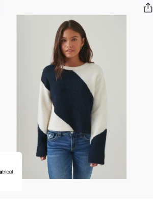 Stickad tröja från Gina Tricot - Snygg stickad tröja med breda diagonala blockmönster i mörkblått och vitt. Tröjan har rund halsringning och långa ärmar med en lite lös passform. Perfekt för att skapa en cool och avslappnad look.