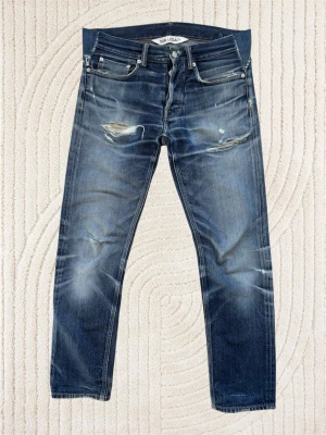 Our Legacy ”First Cut” med Slitningar - Ett par extremt snygga jeans från Our Legacy med öppna slitningar! Mycket fin wash på dessa, utsydda från W29 till W30. Sista bilden visar att främre delen av gylfen förstärkts med extra tyg. Hör av dig bid frågor! Mått: Ytterben - 97 cm,  Midja - 42 cm, Benslut - 17.5 cm