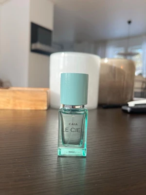 CAIA Le Ciel Eau de Parfum 15 ml - Fräsch parfym från CAIA i modellen Le Ciel. Flaskan är liten och fyrkantig i genomskinligt turkost glas med ett matchande turkost lock och silverdetaljer. Modern och stilren design som känns lyxig och trendig. Perfekt att ha med i väskan. Förvarats mörkt och svalt, flaskan är i 15 ml och är endast testad.