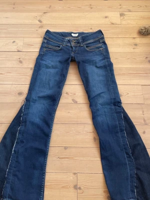 Lågmidjade bootcut jeans - Säljer dessa väldigt lågmidjade jeans i en mörkblå färg som är omsydda till bootcut. Midjemått 37 cm innerbensläng 76 cm. Kontakta mig gårna privat vid frågor eller liknande💗💗