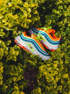 Nike Air Max 97 neonfärgade sneakers - Färgstarka Nike Air Max 97 sneakers med vågiga detaljer i vitt, grönt, blått och orange. Skorna har neongula och orange inslag, lila Swoosh och synlig Air Max-sula. Klassisk snörning och sportig vibe, perfekta för dig som gillar att sticka ut.