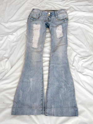 Ljusblå superlågmidjade jeans med slitningar - Sååå sjukt snygga vintage superlågmidjade jeans med slitningar!😩😩💓💓säljer eftersom de inte passar därför har jag ingen bild på! 💓   Innebenslängd: 76 midjemått: 36