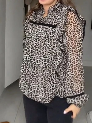 Leopardmönstrad blus med volanger - Trendig blus från Lindex i transparent leopardmönstrat tyg med svarta volangdetaljer och knäppning fram. Blusen har lång ärm med resår vid ärmslut och en lätt v-ringad halsringning. Perfekt för dig som vill sticka ut med ett djurmönster.