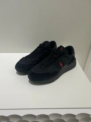 Svarta sneakers från Polo Ralph Lauren - Säljer ett par svarta Polo Ralph Lauren-sneakers i storlek 40. Skorna är i mycket bra skick och används inte längre.