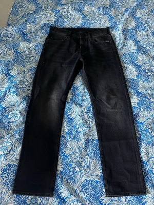 Jeans - Säljer dessa grå-svarta jeans i storlek 31/30 från G-Star. Det är straight passform. Nästan aldrig använda sen jag köpte de för 1300, skriv vid funderingar ! Mått : Midjan 40cm, totala längden 100cm, benöppning 19cm
