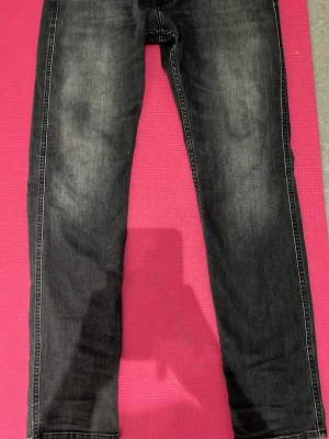 Svarta slim fit jeans från replay  - Snygga svarta slim fit jeans med diskreta slitningar och tvättade detaljer på benen. Klassisk femficksmodell med raka ben och kontrastsömmar. Perfekta till en avslappnad streetwear-look.