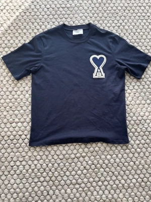 Mörkblå ami paris t-shirt - Helt oanvänd ami paris t-shirt i storlek M. Köpte den av en annan kille på vinted som aldrig heller hade använt den och hade kvar prislapp. Den är i helt nytt skick och var för stor för mig.
