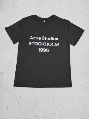 Svart Acne Studios t-shirt - Cool svart t-shirt från Acne Studios med vit text 'Acne Studios STOCKHOLM 1996' på bröstet. Klassisk passform med rund hals och korta ärmar. Perfekt för dig som gillar stilrena och trendiga plagg.