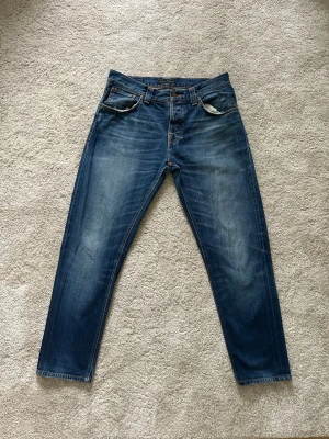 Blåa Nudie Steady Eddie Jeans Storlek W34 L32 - Mycket fina Nudie Jeans i blå färg. | Jeansen är i mycket bra skick och sparsamt använda. |  Äkta som allt annat jag säljer! ✅ |  Storlek: W34 L32 | Skick: Mycket Bra Skick - har lite små slitningar (SE SISTA BILDER) | Färg: Blå | Märke: Nudie | Modell: Jeans |   Hör gärna av dig vid frågor så svarar jag så fort jag kan! 😁 |  (SKU - 210)