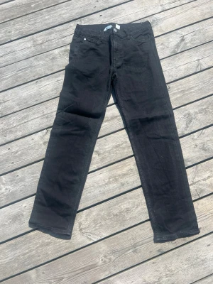 Svarta raka jeans med justerbar midja, från H&M - Säljer ett par svarta jeans från H&M, med rak passformVita sneakers med gulddetaljer och justerbar midja. Klassisk femficksmodell och knappgylf. Perfekta till dig som gillar en enkel och clean look.