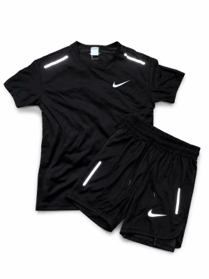 Svart träningsset från Nike - Snyggt svart träningsset från Nike med t-shirt och shorts. Setet har vita reflexdetaljer på axlar och ben samt Nike-logga på både tröja och shorts. Tillverkat i ett lätt och snabbtorkande material som passar perfekt för träning och sport.
