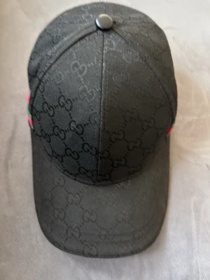 Gucci Keps Svart  - Ren och snygg Gucci-Keps använt runt i cirka 3 månader riktigt fräsch samt är en inte en äkta keps men har ett riktigt bra kvalité. Texturen är riktigt skön.
