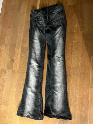 Svarta bootcut jeans från Cheap Monday - Säljer ett par svarta bootcut jeans från Cheap Monday med slitna detaljer och cool tvätt. Storlek 23/30
