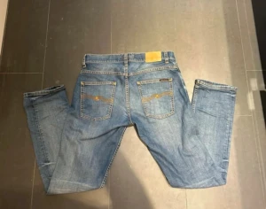Nudie jeans blå - Skicket på jeansen är mycket bra utan defekter skulle säga den är nästan Ny utan prislapp. En sak med Nudie jämfört med till exempel Replay, tiger of Sweden och Jacob cohën är att om eventuella defekter skulle uppnå någon gång så finns möjlighet att lämna in plaggen hos en Nudie butik där kostnadsfria reparationer erbjuds. Priset är förhandlingsbart vid rimligt offert.