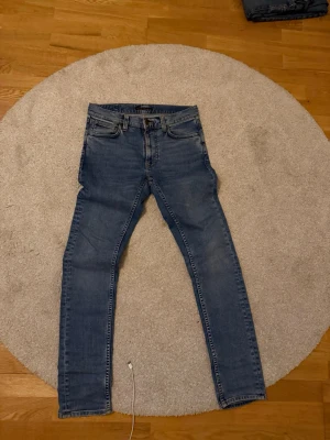 Jeans från Nudie Jeans - Säljer ett par  blå jeans från Nudie Jeans med slim fit. 