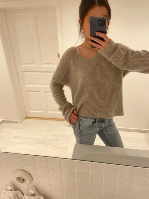 Beige stickad tröja - Inteessekoll. Mysig beige stickad tröja med v-ringning från NA-KD. 🩷