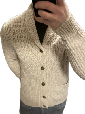 Beige stickad cardigan  - Otroligt snygg beige stickad cardigan. Passar perfekt till kallare väder. Modellen är 180cm, 75kg. Priset kan såklart dikauteras!