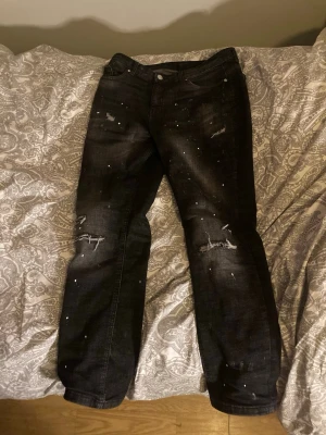 Svarta distressed jeans med färgstänk - Säljer därför jag knappast använt dom. Dom är i nytt skick , sitter perfekt på mig, är 180cm.         Bara att skriva om ni har frågor osv!  Strl: 13-15 yrs . XL LARGE. Pris kan diskuteras