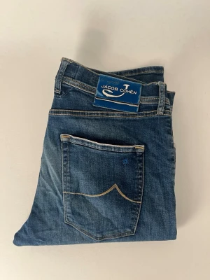 Jacob cohën jeans limited edition 61/75 (exclusive) - Selling a rare pair of Jacob cohën jeans. The size is w33. The condition of the jeans is 8,5/10 no flaws excepts for the light wear on the backflap and a small mark on the left leg. The jeans are from an small collection of only 75 pieces made which makes these very exclusive. If you have any questions feel free to ask. Price is negotiable!