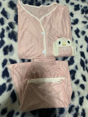 Rosa pyjamas med kaninmotiv - Supersöt rosa pyjamas med ett broderat kaninansikte och texten 'LUCKY'. Oanvänd. Storleken S/M.