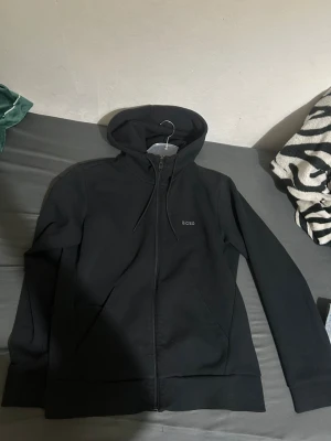 Boss Svart hoodie med dragkedja  - Snygg svart hoodie från Boss, säljs pga den är för liten. Storlek S