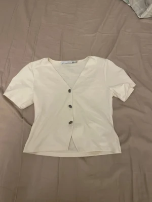 Vit v-ringad topp med knappar - vit topp från lager 157. Knappt använd.