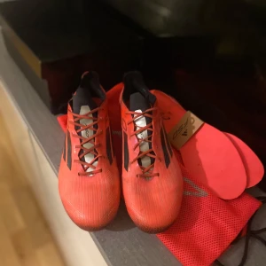 ADIDAS F50 ELITE AG VIVID HORIZON - RÖD/ SVART/SILVER - PRIS KAN DISKUTERAS! Säljer mina Adidas F50 Elite AG i toppskick. Endast lite för stora för mig. ✅ Originalkartong, skopåse & extra innersula ingår ✅ Sällsynt färg & modell ✅, påverkar Pris sätts lågt p.g.a. av att jag måste köpa nya . Först till kvarn! Gör rent innan jag skickar dom, lite smutsiga just nu 