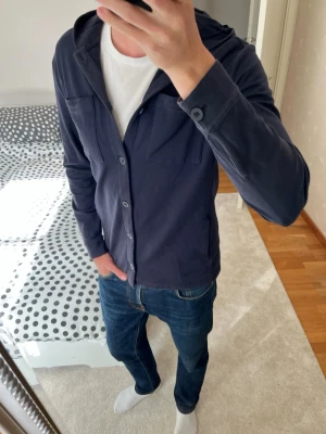 Mörkblå cardigan med huva och knappar från Massimo Dutti - Riktigt fet cardigan hoodie från Massimo Dutti i storleken L! Hoodien är i väldigt fint skick! ——————————————————————————                                                                      📐| Storlek: L                                                           👖| Märke: Massimo Dutti                                      🔎| Skick: Mycket Fint!                                                     ✍🏻| Skriv om du har några frågor