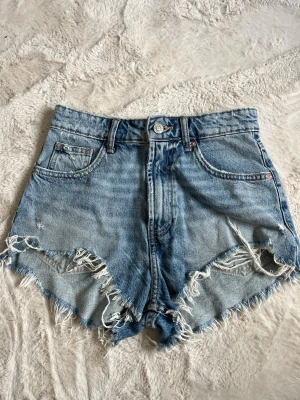 Blåa Zara jeansshorts - Säljer ett par blåa högmidjade jeansshorts från Zara som inte säljs längre. Om man inte gillar högmidjat så är de väldigt enkelt att bara vika ner kanten som både är snyggt och bekvämt! Aldrig använda🩷