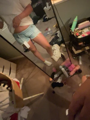 Ljusblå denimshorts med fransar - Säljer ett par ljusblå denimshorts med råa franskantade benslut och klassisk femficksdesign. Shortsen har låg midja och är perfekta för varma dagar. Snygg och avslappnad passform som passar till det mesta.