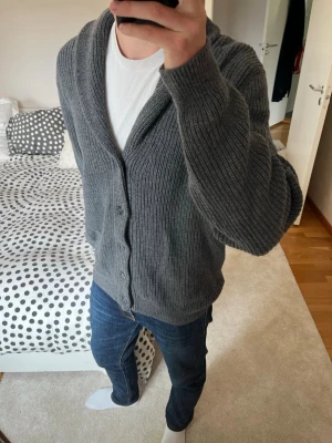 Grå stickad kofta med knappar från Massimo Dutti - En riktigt snygg cardigan från Massimo Dutti tillverkad i tjockt och mjukt material. Cardiganen är i storleken XL utan defekter! ——————————————————————————                                                                      📐| Storlek: XL                                                           👖| Märke: Massimo Dutti                                      🔎| Skick: MYCKET FINT!                                                     ✍🏻| Skriv om du har några frågor