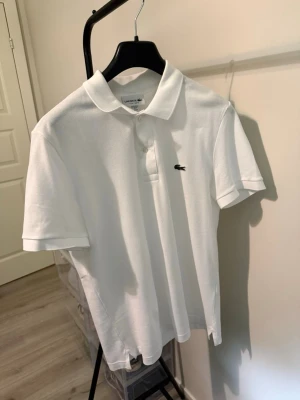 Vit pikétröja från Lacoste - Originell Lacoste piké Slim fit, Strl M. Köptes Maj detta året på Hede Fashion i Göteborg.  Hunnit använda 2-3 gånger endast… Säljes då den är för stor på mig. Strl M, Slim/muscle-fit