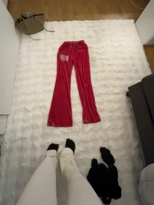 Röda velour mjukisbyxor med strass - Säljer ett par mörk  röda mjukis byxor jätte fina dom har strech i sig och passa mig som är 162 o är lite långa men inte alls farligt säljer dom då de är fullt i min garderob mysigt material känns knappt att man har byxsor på sig❤️🤩