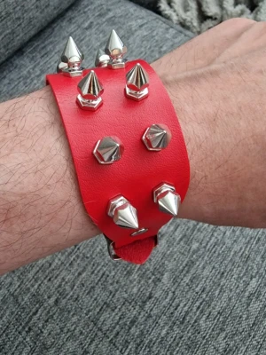 Armband rött spikar - Armband punk rött spikar. PU läder. Längd 24 cm. Bredd 4 cm.