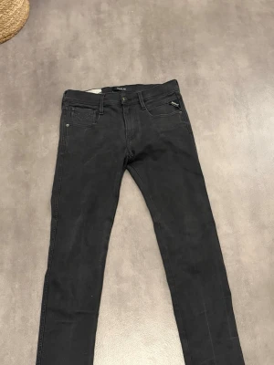 Svarta slim fit jeans från NLY - Säljer ett par svarta slim fit jeans från NLY med klassisk femficksmodell och dragkedja. Jeansen har smal passform och raka ben, perfekta till en avslappnad stil. Materialet är mjukt och stretchigt för extra komfort.