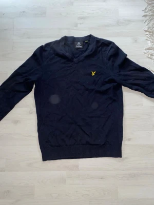 Lyle & scott stickad tröja - Mörkblå stickad tröja med V-ringning och lång ärm. Storleken är S och är från lyle & scott. Tröjan är i utmärkt skick! Priset går att diskutera